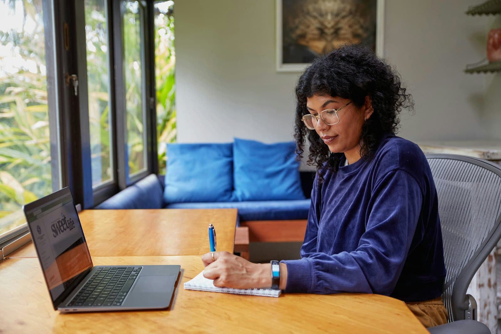 A designer sketching ideas beside her laptop