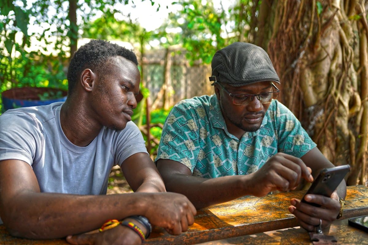 Two men reading a message on a phone