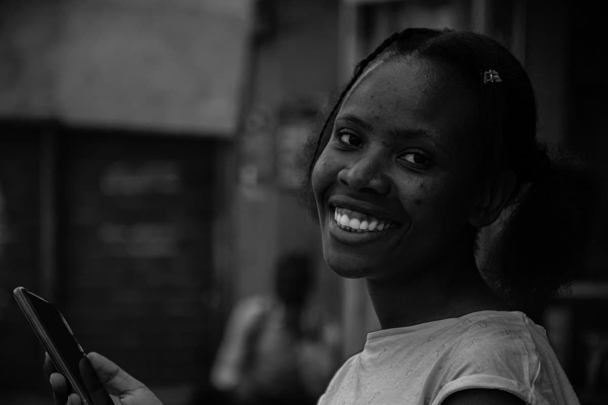 A smiling woman holding her phone